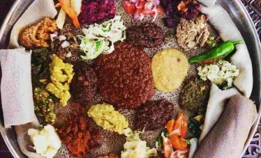 Tourists experiencing a traditional Ethiopian fasting Beyaynet meal in Addis Ababa