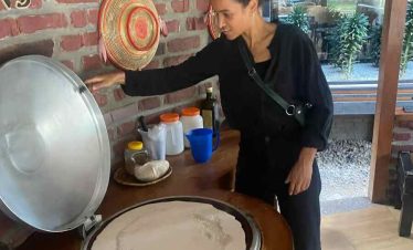 Tourist preparing injera, traditional Ethiopian flatbread, during a cooking experience in Addis Ababa